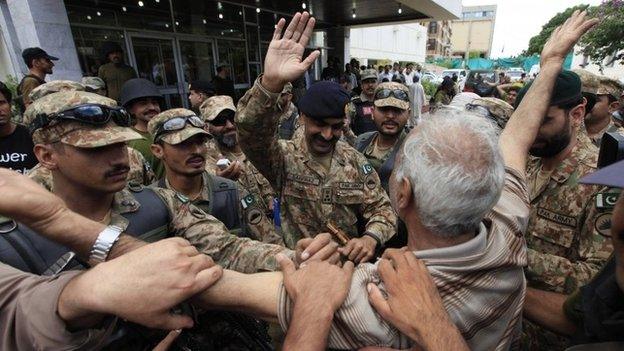 supporter of Tahir ul-Qadri, a Sufi cleric and leader of Pakistan Awami Tehreek (PAT) party, cheers upon seeing an army commander after fellow supporters stormed the building of the state television channel PTV, during the Revolution March in Islamabad September 1, 2014.