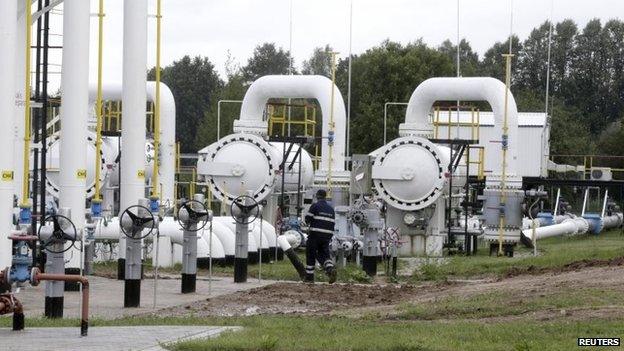 A specialist walks past pipes at a gas storage facility in Latvia