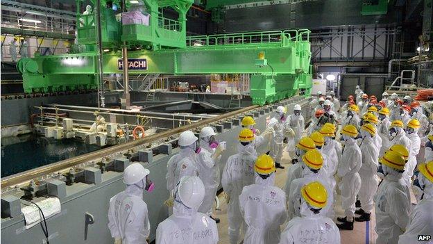 Tepco workers watching an operation to move a spent fuel rod to a cask in the spent fuel pool of the unit four reactor building in 2013