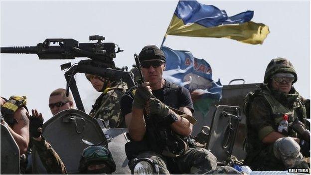 Ukrainian servicemen ride on armoured vehicles near Slaviansk