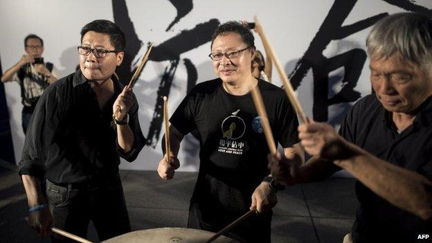 Benny Tai (centre), co-founder of the Occupy Central movement, hits a drum next to other democracy activists at a rally near the Hong Kong government complex on 31 August 2014