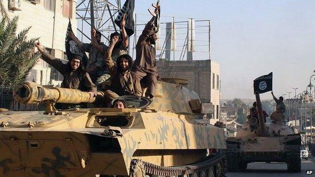 Islamic State fighters drive armoured vehicles through Raqqa, Syria (30 June 2014)