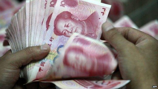 This picture taken on 17 August 2012 shows a Chinese bank staff member counting stacks of 100-yuan notes at a bank in Huaibei, east China's Anhui province.