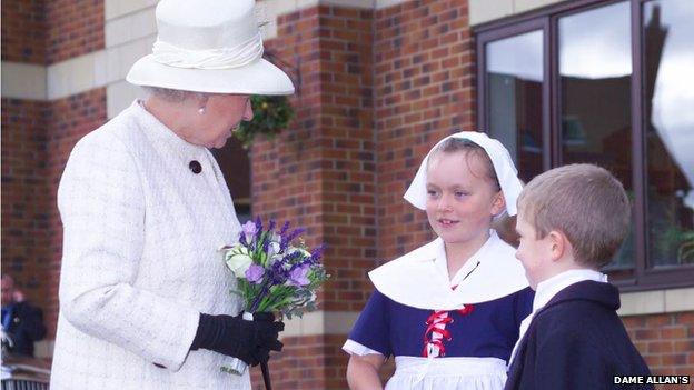 A Dame Allan's girl meets the Queen wearing a "Polly Bell"