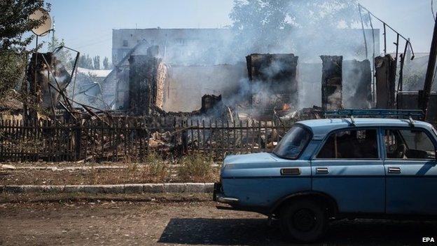 Car passes shelled buildings in eastern Ukraine