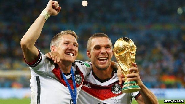 Bastian Schweinsteiger and Lukas Podolski of Germany celebrate with the World Cup trophy after defeating Argentina 1-0 in extra time in the 2014 final