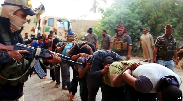 Islamic State fighters lead away captured Iraqi soldiers after taking over a base in Tikrit, Iraq - 14 June 2014