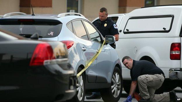 Cobb County police investigate an SUV where a toddler died Wednesday, June 18, 2014, near Marietta, Ga., when the father forgot to drop his child off at day care and went to work.