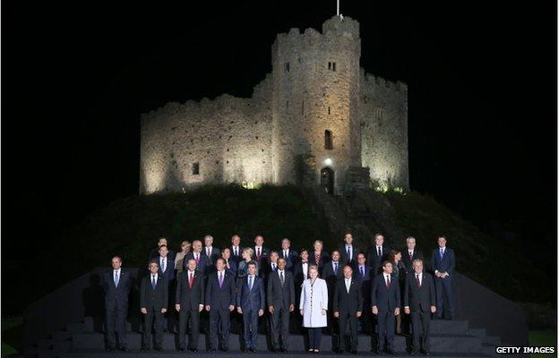 World leaders gathered at night for a photograph outside Cardiff Castle, which is lit up in the background