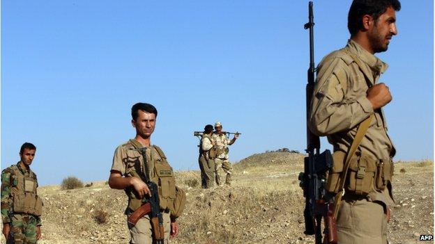 Iraqi Peshmerga fighters carrying weapons