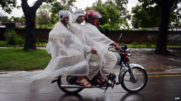 Men in Islamabad in ponchos amid heavy rain - 4 September