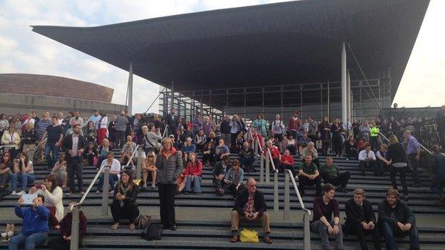 Onlookers took seats on the steps of the Senedd