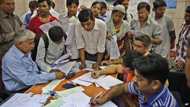 Indians gather inside a state-owned bank to open accounts as part of a countrywide campaign to open millions of accounts for the poor in Delhi on Thursday, Aug. 28, 2014.