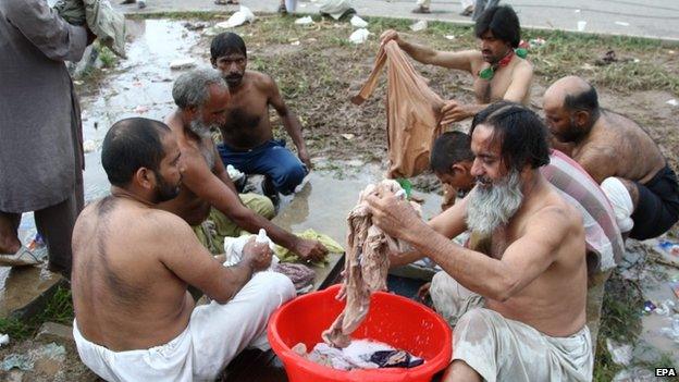 Supporters of Pakistani Muslim cleric Tahirul Qadri wash their clothes on the premises of the Parliament building during an anti-government protest