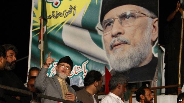 Pakistan's fiery cleric Tahir-ul-Qadri, second left, gestures while delivering his speech during a protest in Islamabad, Pakistan,