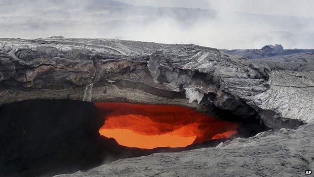 This Aug. 12, 2014 photo released by the U.S. Geological Survey shows a fluid lava stream within the main tube of the June 27 lava flow from the Kilauea volcano Pahoa, Hawaii