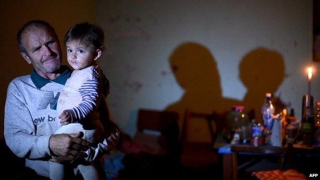 A man carries his granddaughter on September 5, 2014 in a high school in Yasynuvata, near Donetsk