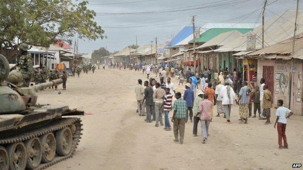 A handout picture taken and released on 31 August 2014 by the African Union-United Nations Information Support Team shows residents of the town of Bulomarer, some 160kms (100 miles) south-west of the capital Mogadishu, in the Lower Shabelle region of Somalia walking in a street after it was liberated by African Union Mission in Somalia troops