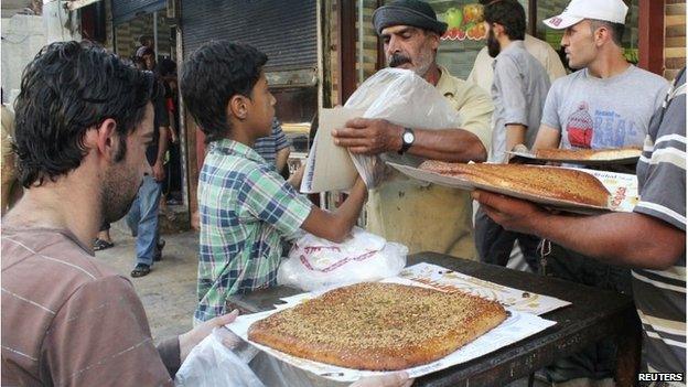 A vendor sells traditional bread during the Muslim holy fasting month of Ramadan in Raqqa province, eastern Syria, which is controlled by the Islamic State, July 23