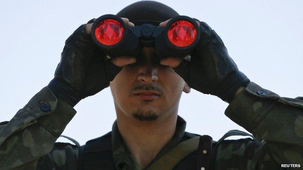 A pro-Russian separatist looks through binoculars on the outskirts of Donetsk. Photo: 6 September 2014