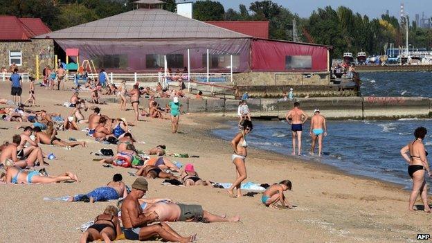 People enjoy the sun on a beach in Mariupol, south-eastern Ukraine. Photo: 6 September 2014