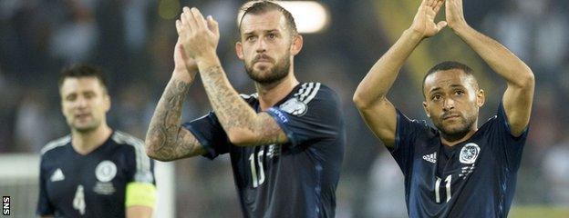 Russell Martin, Steven Fletcher and Ikechi Anya salute the Scotland fans after the match