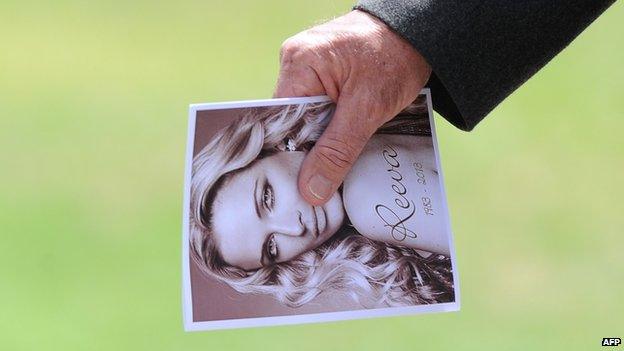 A relative of late South African model Reeva Steenkamp holds the funeral program upon arriving at the crematorium building in Port Elizabeth on February 19, 2013