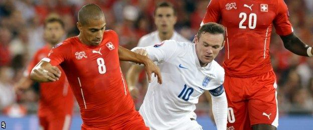 England's Wayne Rooney, right, fights for the ball with Switzerland's Gokhan Inler