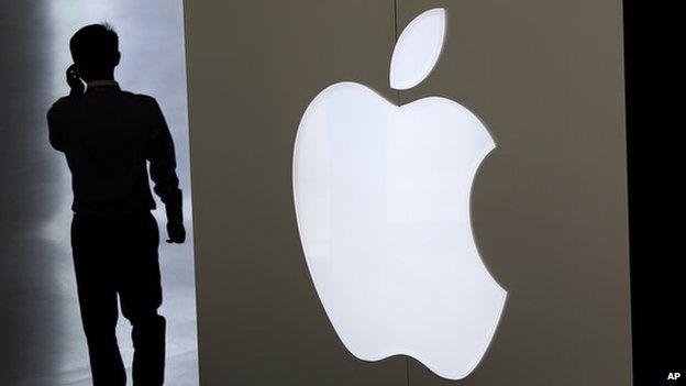 Man walks past Apple logo.