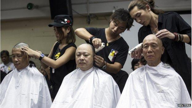 Founders of the Occupy Central movement (from L to R), academic Chan Kin-man, academic Benny Tai and Reverend Chu Yiu-ming, shave their heads during a protest to call for people to join them for an upcoming rally in Hong Kong (9 September 2014)