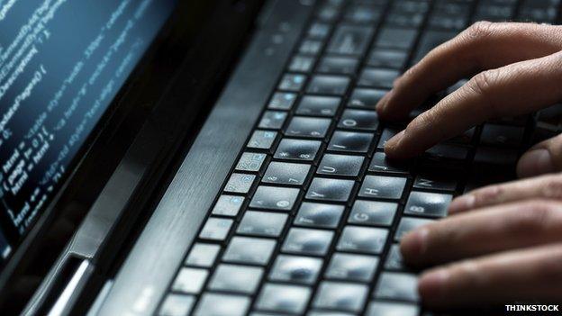 A man typing on a laptop