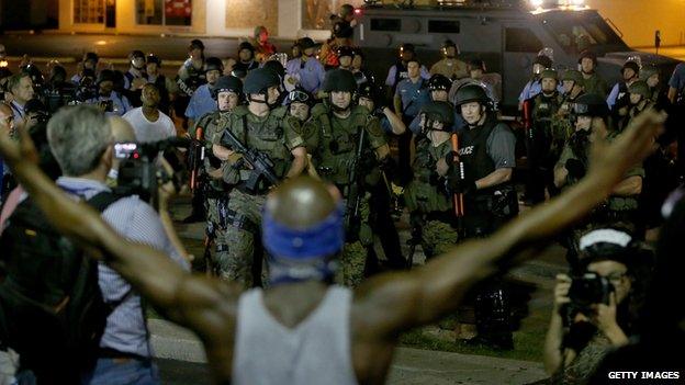 A demonstrator stands in front of police in Ferguson, Missouri, on 19 August, 2014.