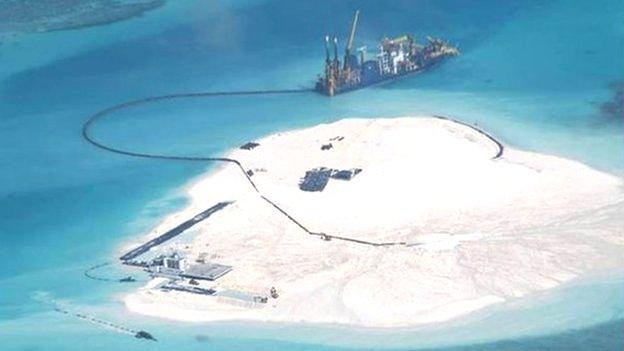 In this 25 Feb 2014 file photo taken by surveillance planes and released 15 May by the Philippine Department of Foreign Affairs, a Chinese vessel, top centre, is used to expand structures and land on the Johnson Reef, called Mabini by the Philippines and Chigua by China, at the Spratly Islands in the South China Sea, Philippines.