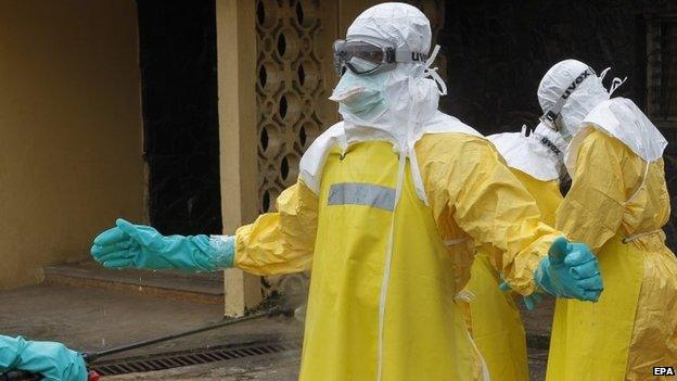 Health worker being sprayed with disinfectant