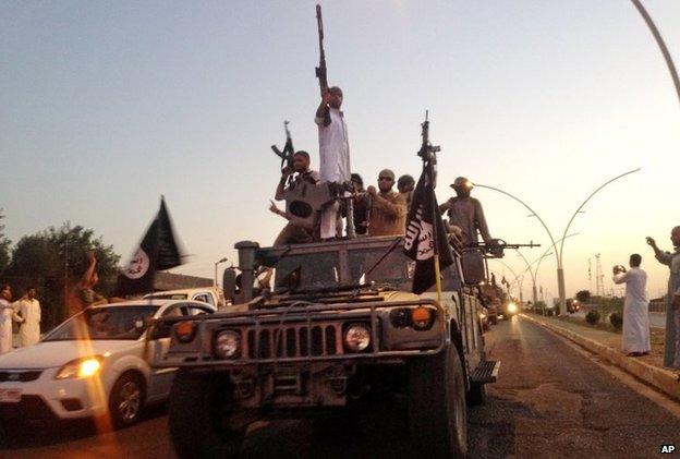 Fighters from the Islamic State group parade in an Iraqi security forces armoured vehicle in Mosul, Iraq. undated picture