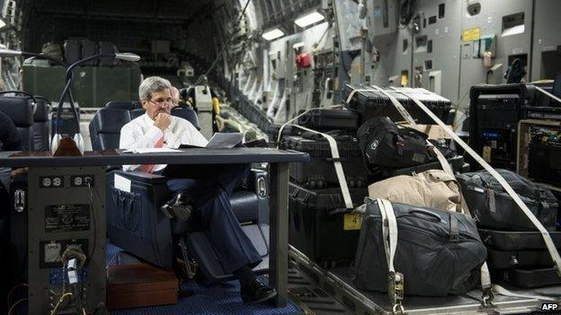 John Kerry looks over papers while flying from Jordan to Iraq on September 10