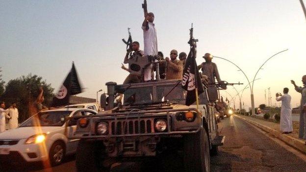 Fighters from the Islamic State group parade in an Iraqi security forces armoured vehicle in Mosul, Iraq. undated picture