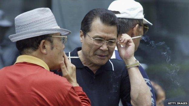 Elderly South Korean job seekers smoke during an elderly persons' job fair on 23 September 2005 in Seoul, South Korea.