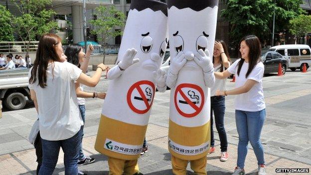 South Korean activists hit cigarette-shaped outfits during a campaign marking the World No Tobacco Day in Seoul on 31 May 2013.