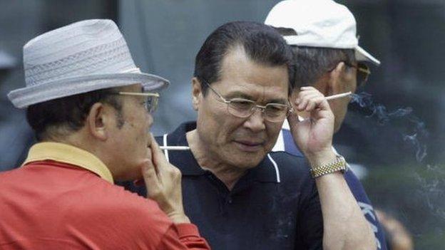 Elderly South Korean job seekers smoke during an elderly persons' job fair on 23 September 2005 in Seoul, South Korea.