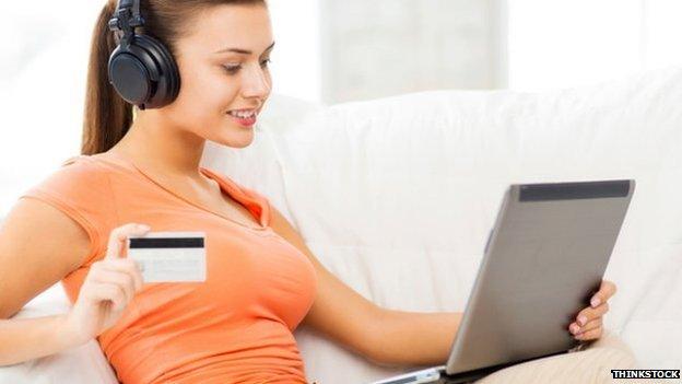 Woman listening to music while making online purchase