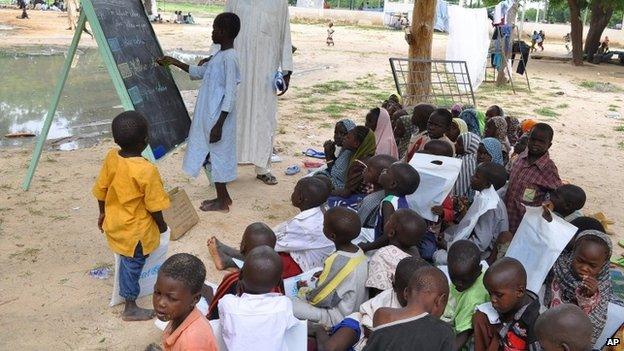 Children who fled their homes following an attacked by Islamist militants in Bama, take a lesson at a camp in Maiduguri, Nigeria, 9 September 2014