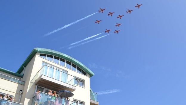 Spectators in Guernsey watch the Red Arrows flypast