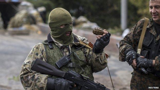 A Pro-Russian rebel holds a hand grenade at a checkpoint near the airport in Donetsk