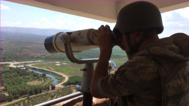 A Turkish serviceman monitors border