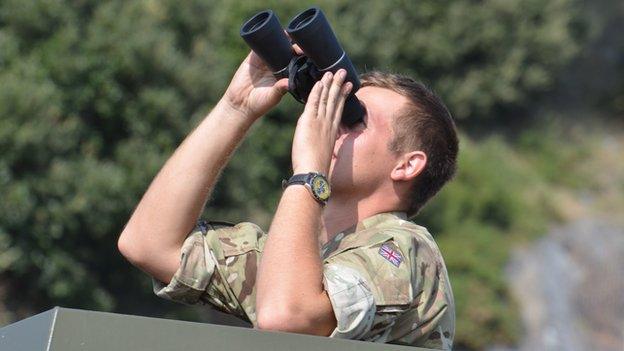 Soldier looks through binoculars