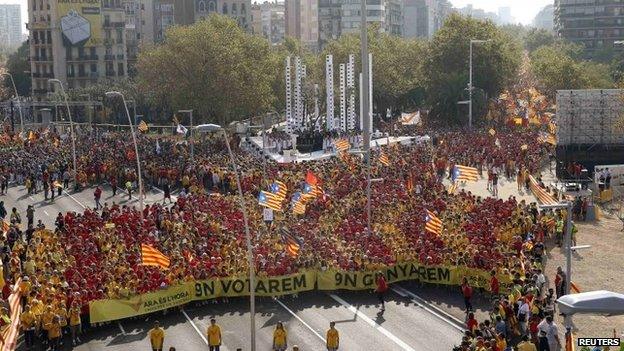 People form a "V" for "vote" in red and yellow, the colours of the Catalan flag, during a gathering to mark the Calatalonia day "Diada" in central Barcelona, 11 September 2014