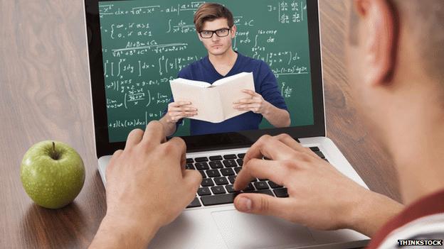 A laptop with a teacher reading from a book