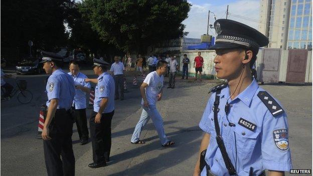 Police officers stand guard outside the court house, blocking roads to the Guangzhou People's Court in the southern Chinese city of Guangzhou 12 September 2014.