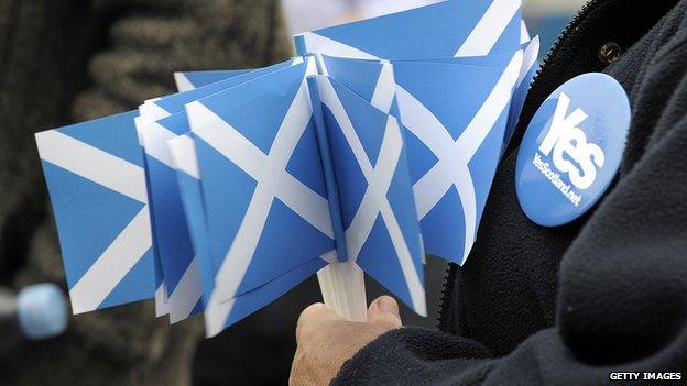 A pro-independence supporter holds Scottish flags